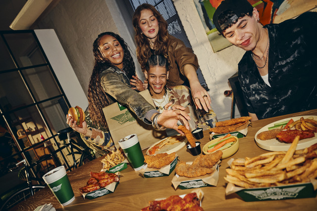 Friends sharing wings, fries and drinks at a table