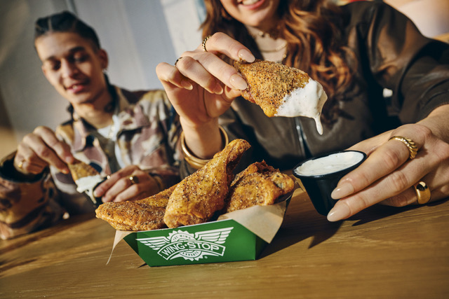 Two people eating lemon pepper wings
